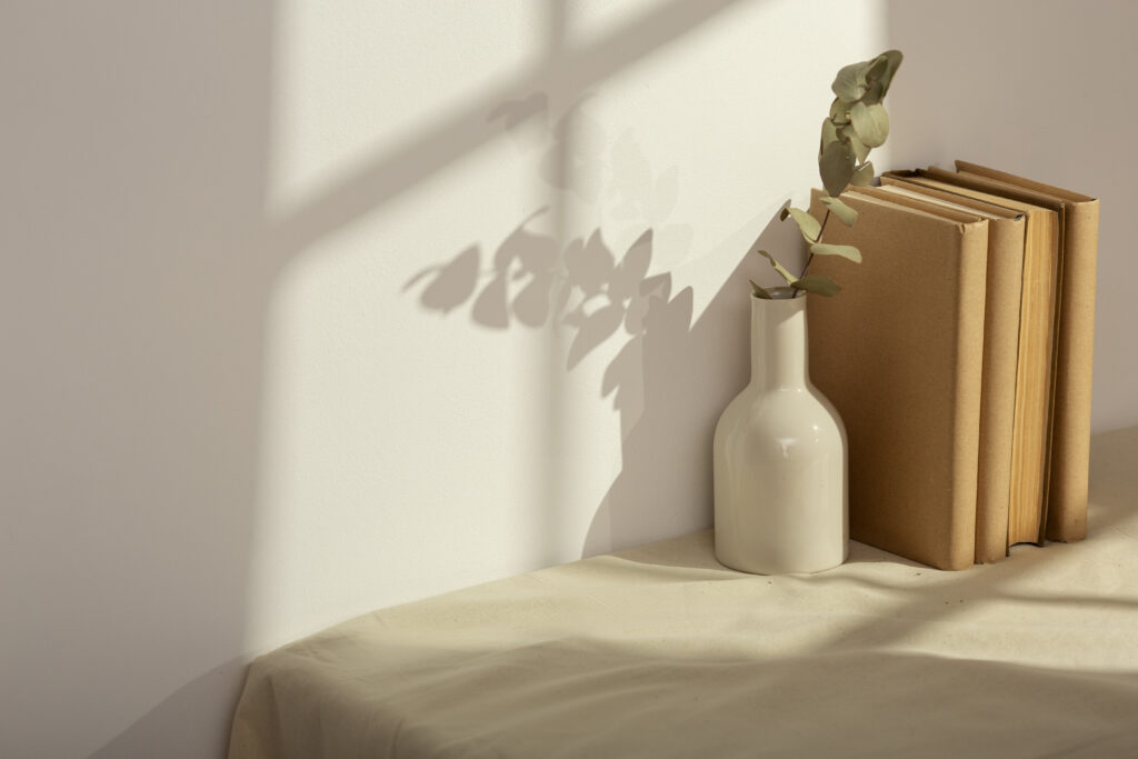 Table avec une nappe sur laquelle est posé une vase contenant des fleurs ainsi que des livres